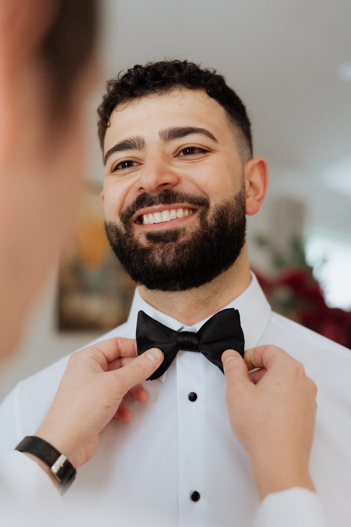 Groom Morry adjusting his bow tie on the morning of his wedding
