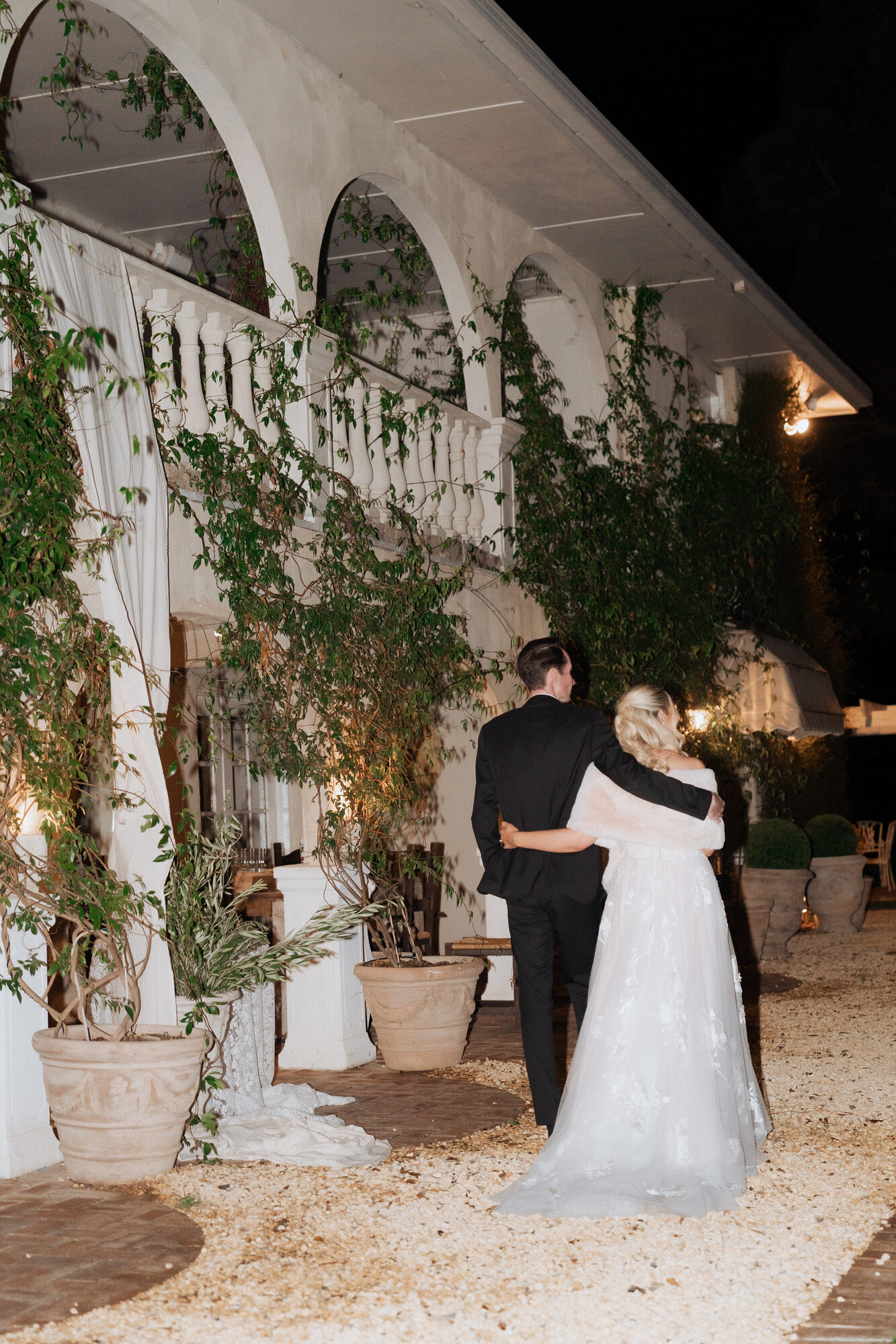 El and Craig under the night colonnade at Villa Toscana — Hunter Valley wedding reception
