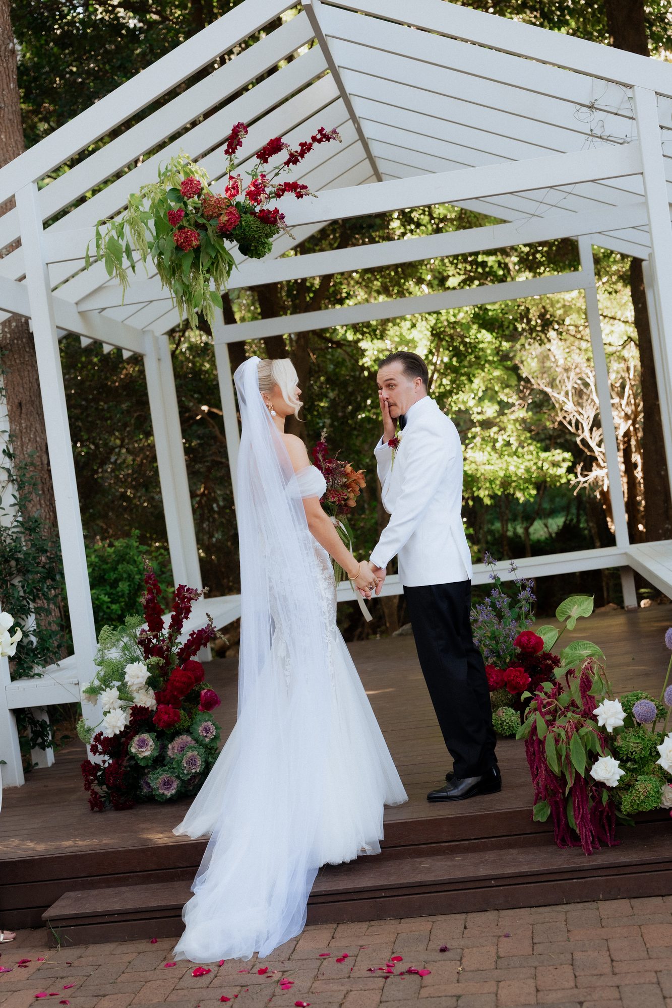 Elena and Bill exchanging vows under the white pergola — The Lodge Jemberoo wedding ceremony